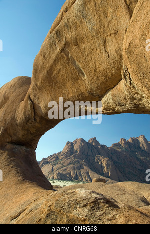 Blick durch ein Felsbogen auf Spitzkoppe und kleinen Spitzkoppe, Namibia, Damaraland Stockfoto