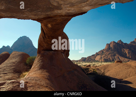 Blick durch ein Felsbogen auf Spitzkoppe und kleinen Spitzkoppe, Namibia, Damaraland Stockfoto