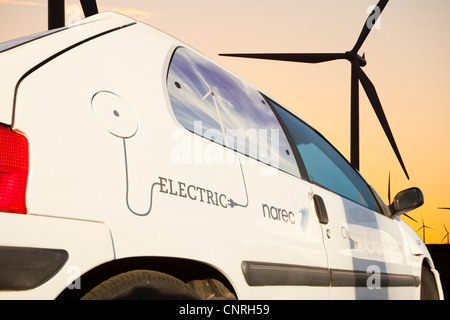 Ein Elektroauto im Morgengrauen über Whitlee Windpark auf Eaglesham Moor südlich von Glasgow in Schottland, Großbritannien Stockfoto