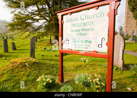 Jesus Church in Troutbeck, Lake District, UK, mit wilden Narzissen blühen in den Kirchhof. Stockfoto