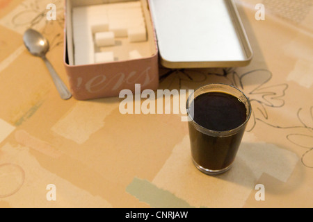 Glas Kaffee und Schachtel Würfelzucker Stockfoto
