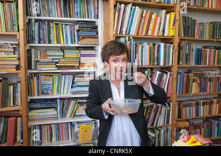 Der Besitzer von einem Antiquariat in Falmouth, Cornwall frisst ihr Mittagessen stehen. Stockfoto