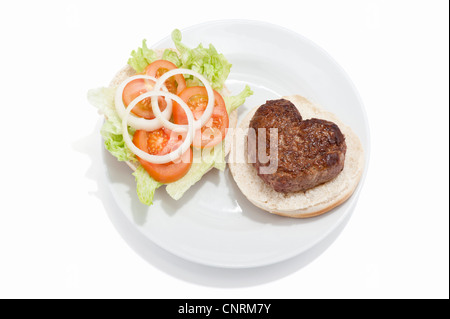 Eine herzförmige Beef-Burger auf einem Brötchen mit einem Beilagensalat Stockfoto