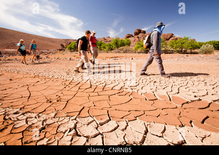 Trekker passieren ein ausgetrocknetes Flussbett im Anti-Atlas-Gebirge in Marokko, Nordafrika. Stockfoto