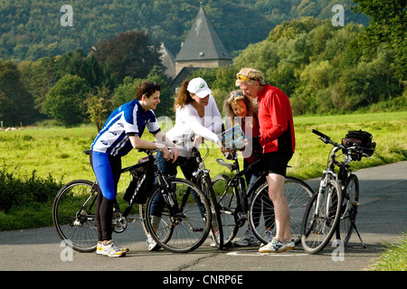 vier Personen auf der Ruhr-Tal-Radweg beobachten, Landkarte, Kemnade Burg im Hintergrund, Witten, Ruhrgebiet, Nordrhein-Westfalen, Deutschland Stockfoto