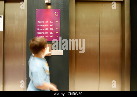 rufen den Lift. Kleiner Junge acht Jahre alt Stockfoto