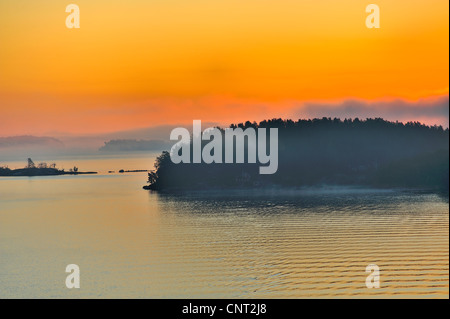 Die Stockholmer Schären entlang der schwedischen Küste von der Ostsee bei Sonnenaufgang gesehen. Sommer Holiday Cottages sind nur in den frühen Morgen Nebel sichtbar. Es war eine weiße Nacht, als ich das erste mal um 4:30 Uhr aufwachte, aber dann Farbe schlich sich in den Himmel und bald gab es eine majestätische Sonnenuntergang. Diese hohen Winkel fast Luftaufnahme vom oberen Deck von einem großen Kreuzfahrtschiff genommen wurde. Die Zeit in der ITPC-Daten ist falsch, wie ich in mehreren Zeitzonen gewesen und hatte es nicht geändert. Stockfoto