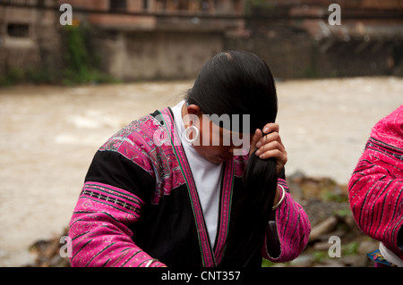 Yao Frau, die ihre langen Haare kämmen, Huangluo Dorf, im südlichen China Stockfoto