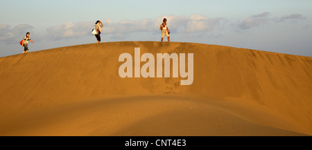 Touristen in den Dünen von Maspalomas. Drei Frauen, die zu Fuß durch die Dünen, Kanarische Inseln, Gran Canaria Stockfoto