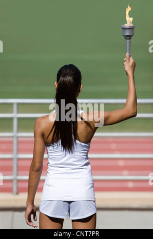 Sportlerin, hält Fackel, Rückansicht Stockfoto