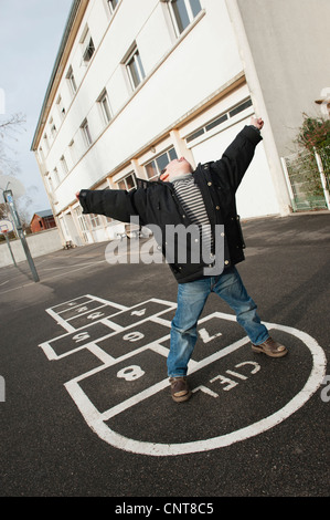 Junge, Himmel und Hölle, Neigung zu spielen Stockfoto