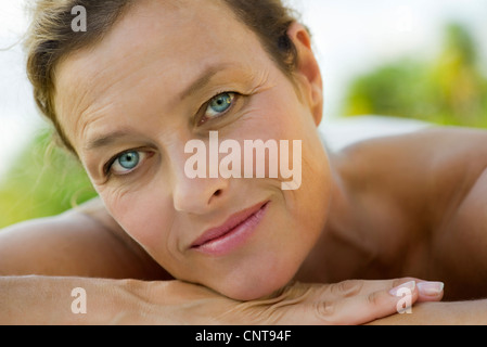Reife Frau, die auf Arme, Kopf ruht Porträt Stockfoto