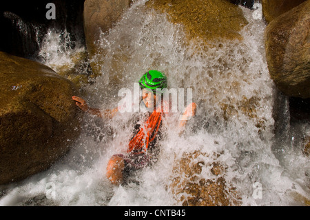 junge Frau beim Canyoning in Korsika Bavella-Gebirge in einem Wasserfall, Frankreich, Corsica Stockfoto