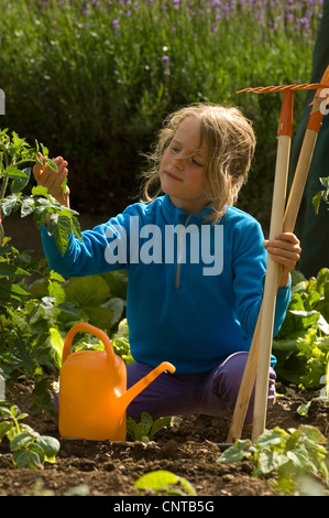 8 Jahre altes Mädchen im Garten, Frankreich Stockfoto