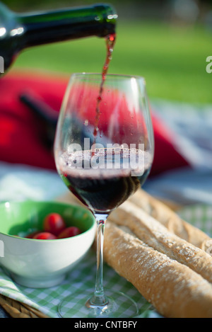 Gießen Rotwein bei Picknick Stockfoto