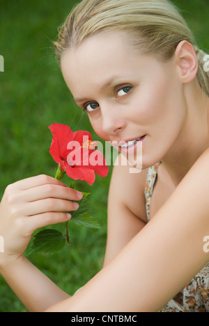 Junge Frau mit Hibiskusblüte, Porträt Stockfoto