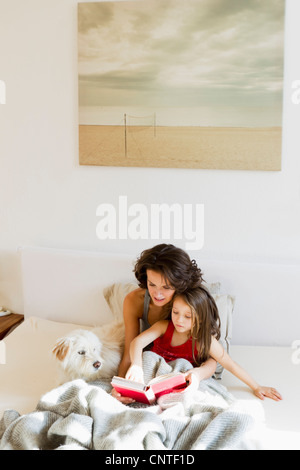 Mutter und Tochter im Bett lesen Stockfoto
