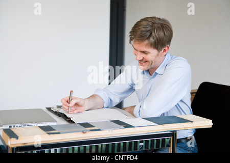 Lächelnde Geschäftsmann arbeiten am Schreibtisch Stockfoto