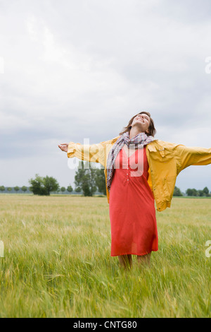 Lächelnde Frau stehend in hohe Gräser Stockfoto