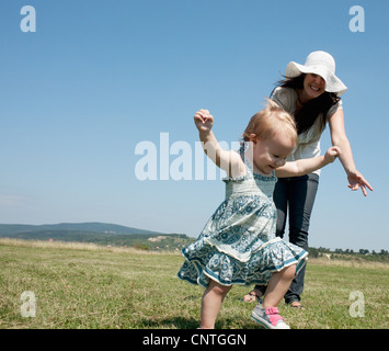 Mutter und Tochter, die zu Fuß in Feld Stockfoto