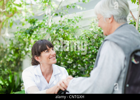 Krankenschwester im Gespräch mit älteren Patienten im freien Stockfoto