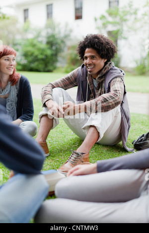 Studenten sprechen auf Rasen auf dem campus Stockfoto