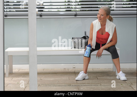 Ältere Frau Trinkwasser im Fitness-Studio Stockfoto