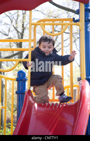 Drei Jahre spielt alter Junge alleine auf einem Spielplatz in Brooklyn, New York. Elternteil ist in der Nähe von. Stockfoto