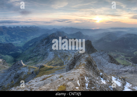 Alpine zerlumpten scharfe Karst Mountain Top Bereiche verschwinden in nebliger Ferne und grünen Wiese bei Sonnenuntergang, Schweiz Stockfoto