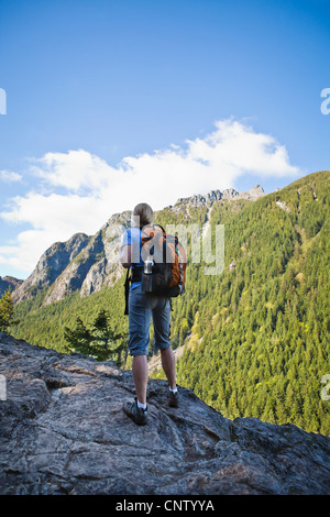 Eine Frau Wanderer Stand am Rande einer Felswand nach oben auf einem Berg, Little Si Trail, Washington, USA. Stockfoto