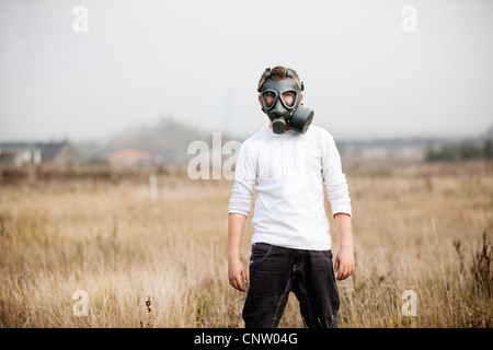 Junge mit Gasmaske im Weizenfeld Stockfoto