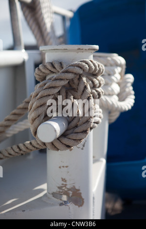 Ein Liegeplatz-Seil um die Bitts eines kleinen Schiffes gebunden Stockfoto