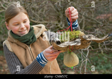 Mädchen präsentieren einen Self-made-Dispenser für Verschachtelung material Stockfoto