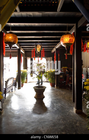 Vertikale Innenansicht von Quan Thang Haus, ein traditionelles Haus in Hoi An, Vietnam mit mit Laternen auf dem Flur. Stockfoto