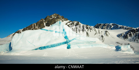 Eisberg mit blauen Adern vor Bergkette, Grönland, Ostgroenland, Tunu, Kalaallit Nunaat, Liverpool Land Lillefjord Stockfoto