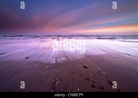 Sonnenaufgang am frühen Morgen wirft eine rosa Färbung über die Flut an Dornweiler Strand auf der Norfolk-Küste, UK Stockfoto