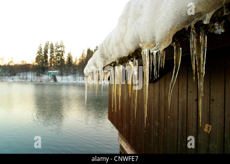 Eiszapfen bilden auf dem Dach eines Hauses Holzboot, Lake Bled, Slowenien, Bled Stockfoto