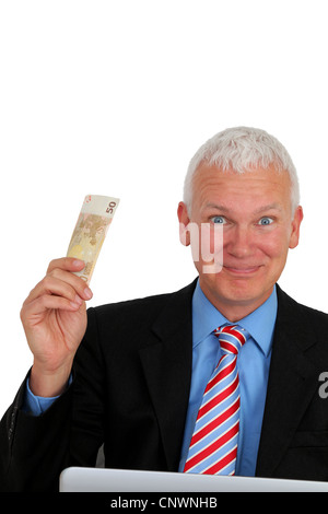 Senior-Unternehmer mit Geld und Laptop lachen Stockfoto