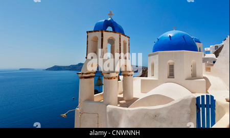 Einen Panoramablick über ein paar der berühmten blauen Kuppelkirchen von Oia auf der griechischen Insel Santorin. Stockfoto