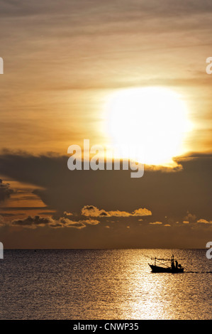 Ein Fischerboot aus Thailand setzt die Segel bei Sonnenaufgang ist es hoffentlich volle Netze und Körbe zu sammeln. Stockfoto