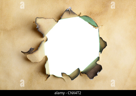 Nahaufnahme des Lochs durch alte gelbe Papier verbrannt Stockfoto