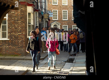 Asiatische Reisegruppe besuchen den Shambles Einkaufsviertel von York in England Stockfoto