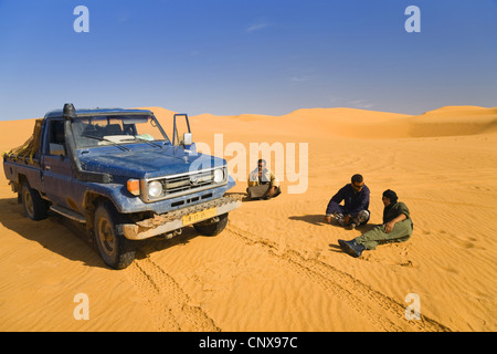 drei Männer ruht neben ihren Geländewagen in der Sandwüste, Libyen Stockfoto