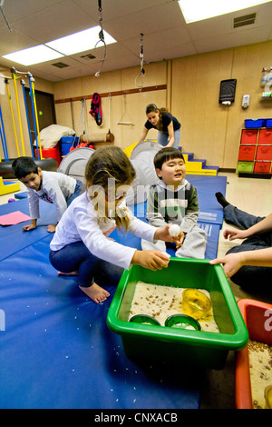 Blinde und sehbehinderte Kinder sieben Sand um die taktile Wahrnehmung bei blinden Kindern Learning Center zu verbessern. Stockfoto