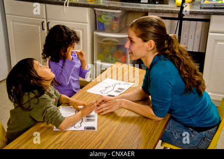 Ein Lehrer führt ein blindes Kind Hände über den Umriss einer Eidechse in erhöhten Art in einem besonderen Bedürfnissen, die Klasse zu schreiben. Stockfoto