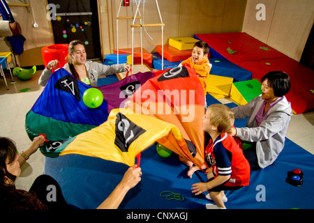 Lehrer und sehbehinderte Schüler Welle einen Fallschirm, Problemlösung in einer sensorischen motor Gruppe zu fördern. Stockfoto