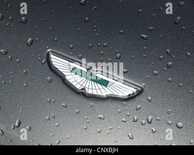Aston Martin Emblem auf Motorhaube mit ausgefallenen metallic Lackierung mit Regentropfen. Stockfoto