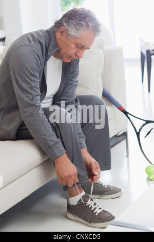 Ein senior Mann seine Schnürsenkel binden vorbereiten, Tennis zu spielen Stockfoto