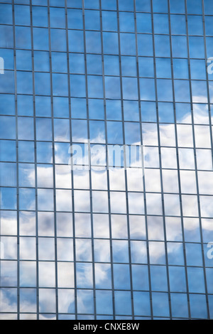 Wolken und Himmel spiegeln sich im verspiegelten Fenster eines Bürogebäudes Stockfoto