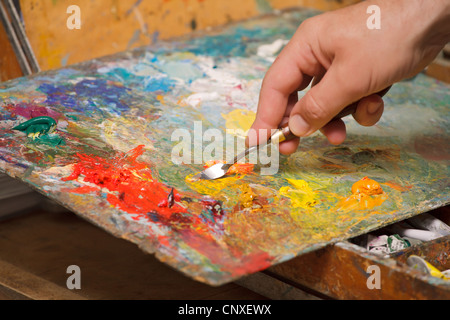 Künstler mischt Ölfarben sich mit einem Spachtel. Horizontale Bilder, close-up. Stockfoto